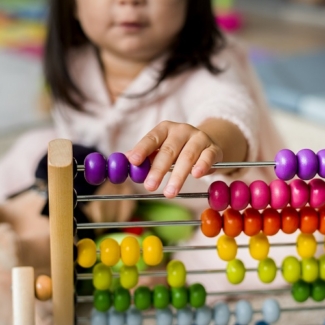 Little girl playing abacus for counting practice